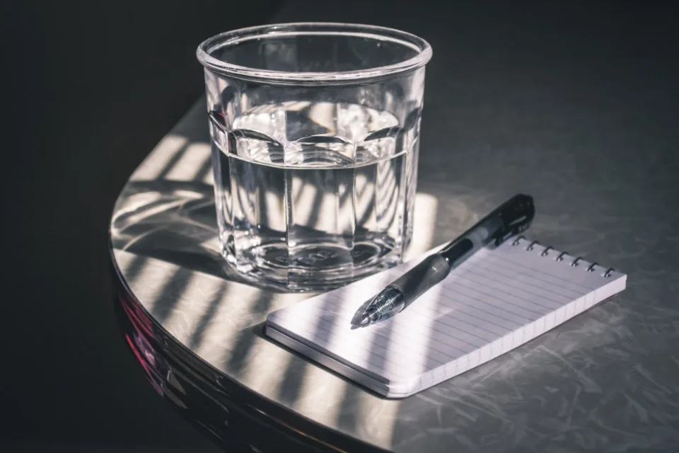 a planner, a notebook and a pen laid out on a desk