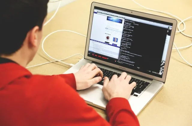 a laptop open on a desk with source code on the screen