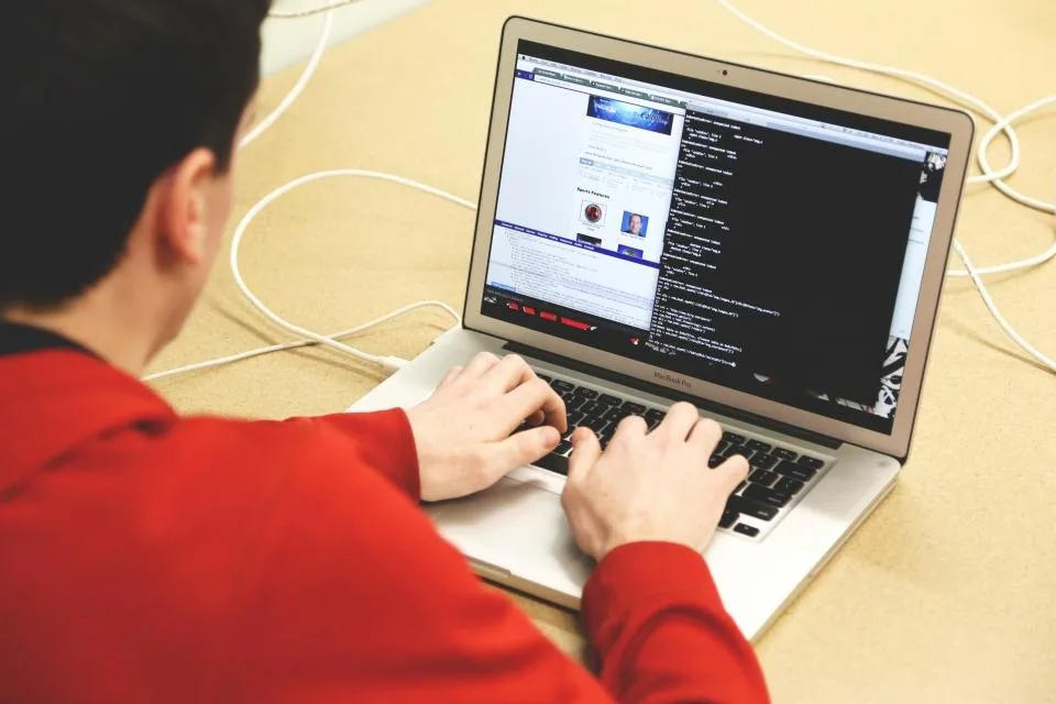 a laptop open on a desk with source code on the screen