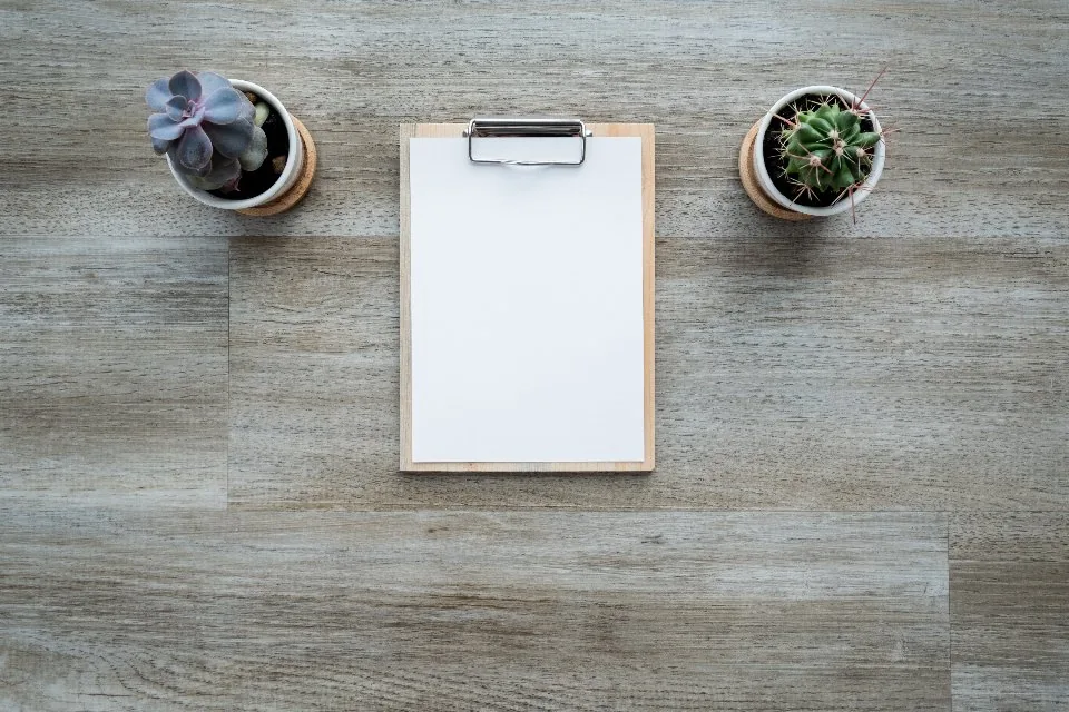 printed documents, a clipboard and a pen spread across a desk