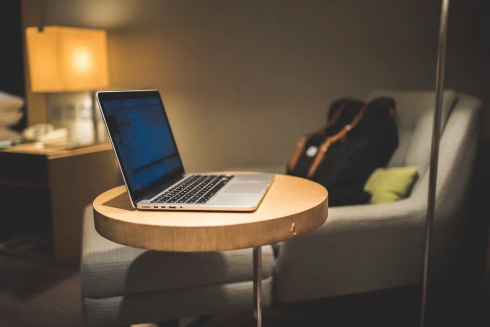 a desk by a window with a laptop open in daylight