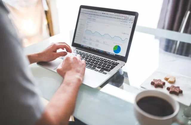 a laptop and a monitor showing charts and performance reports