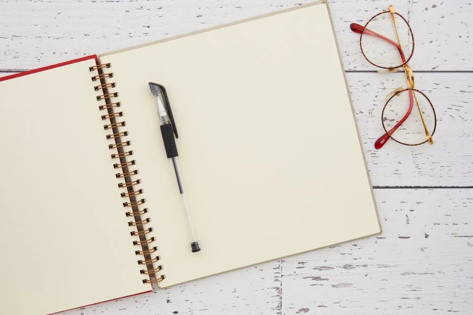 printed documents, a clipboard and a pen spread across a desk