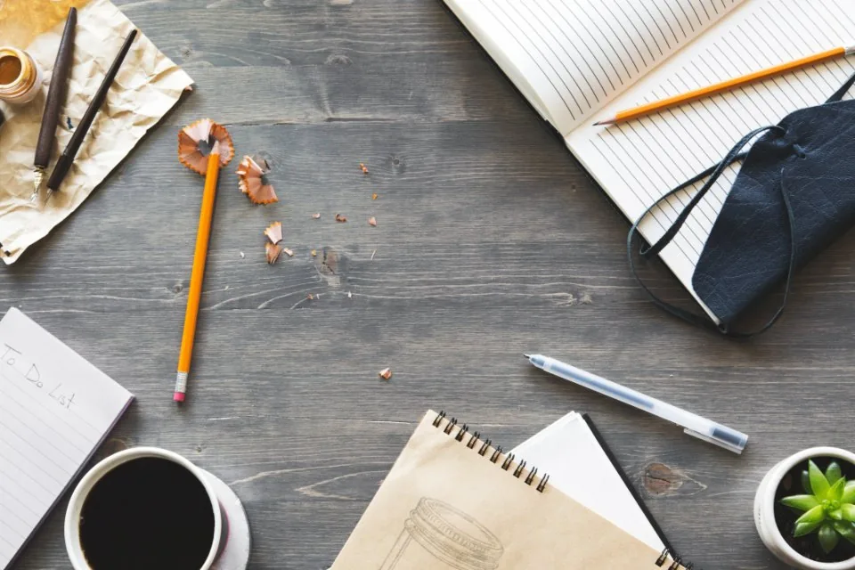 printed documents, a clipboard and a pen spread across a desk