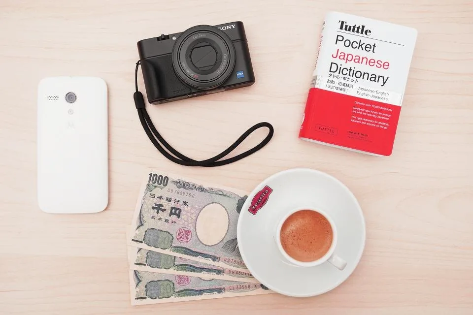 a laptop showing a financial report beside a notebook, a calculator and a phone