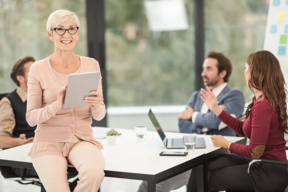 a team working at laptops around a table in a bright office