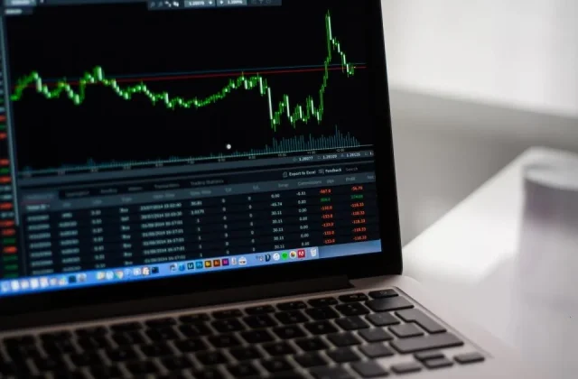 a laptop and a monitor showing charts and performance reports