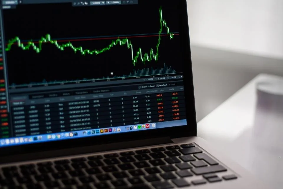 a laptop and a monitor showing charts and performance reports