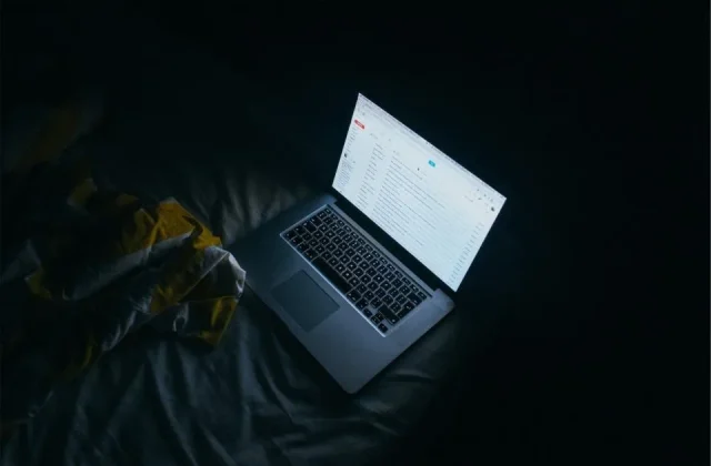 a laptop open in low light with a mail client on screen