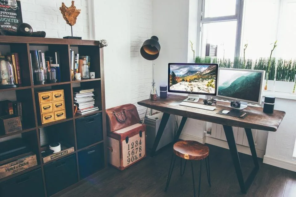 shelves of books in a library with a desk and a laptop in front of them