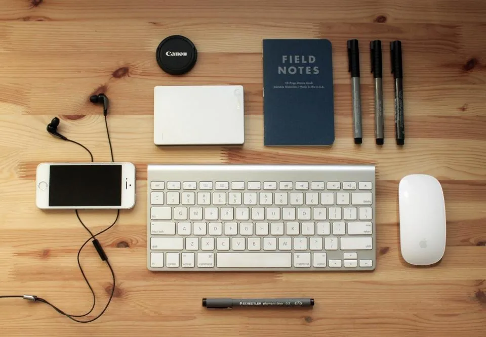 a spiral notebook and pen laid out on a wooden desk
