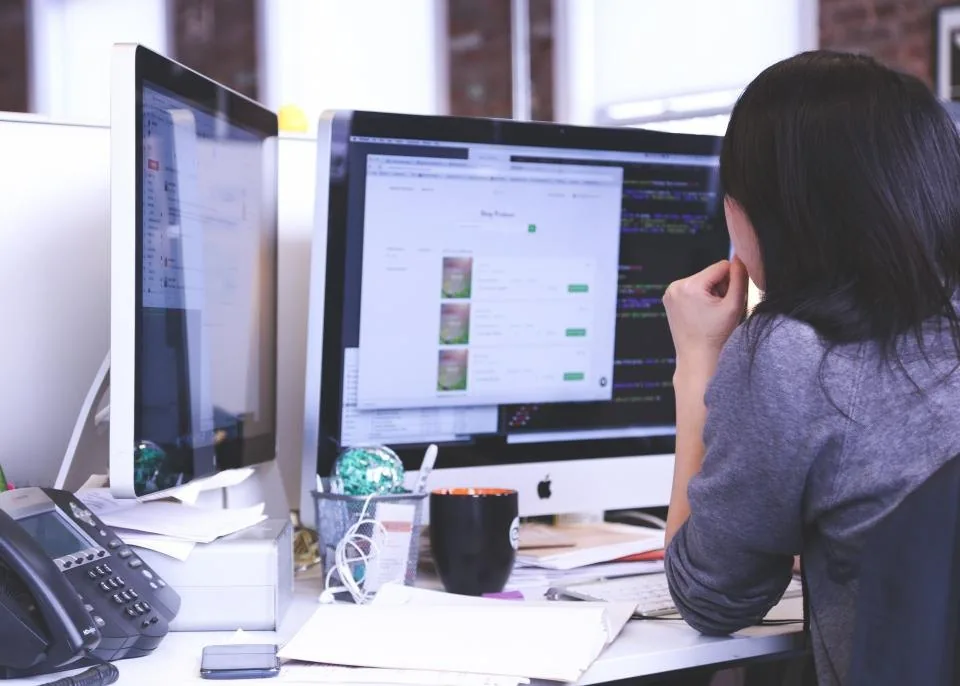 a team working at laptops around a table in a bright office
