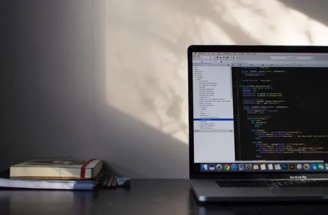 a laptop in a dark room showing a code editor