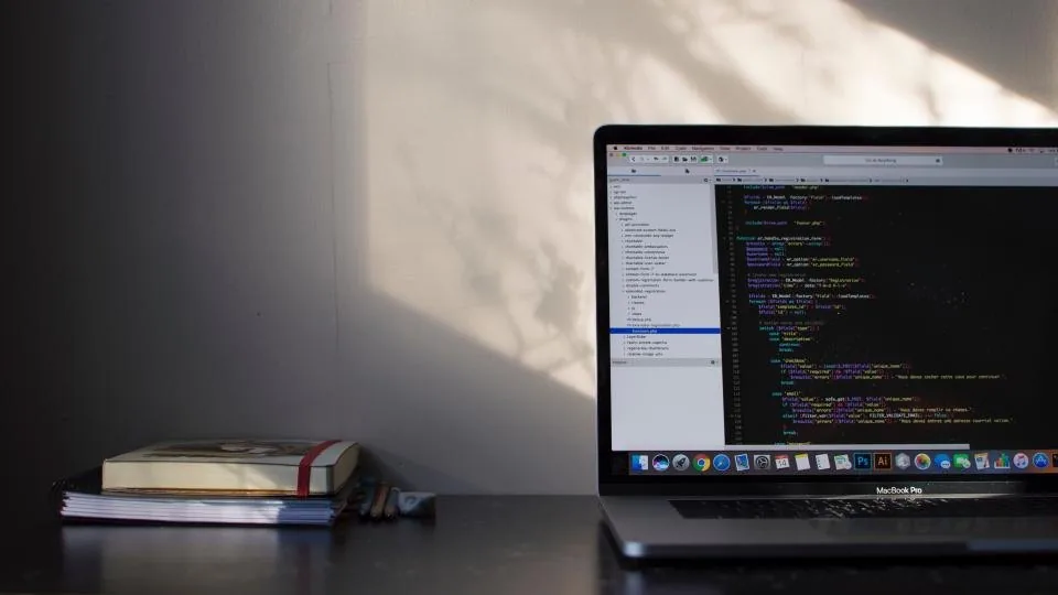 a laptop in a dark room showing a code editor