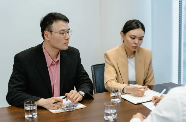 A team discussing project documents during a client meeting.