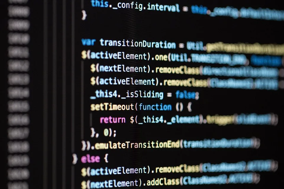 a laptop open on a desk with source code on the screen