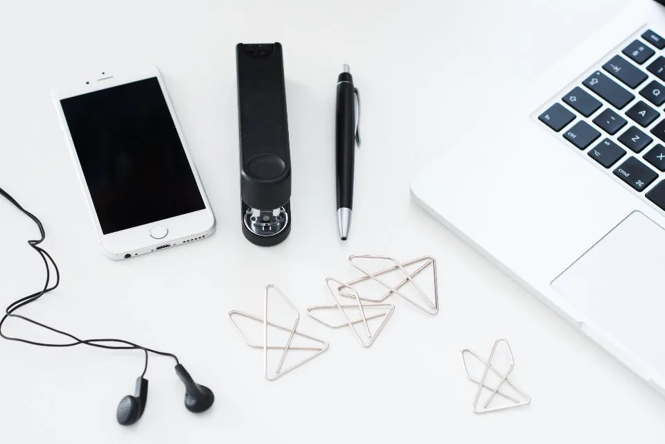 a desk with a laptop, a headset and a phone arranged for calls