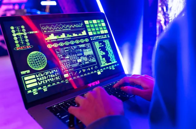 A developer working with a secure data display on a laptop in a controlled workspace.