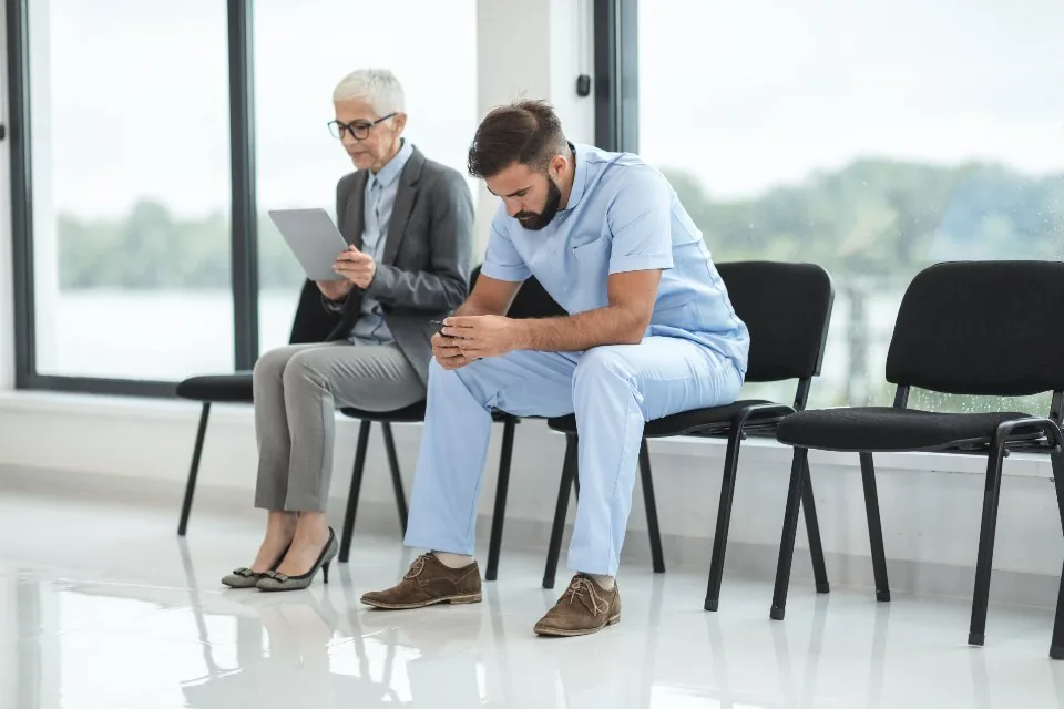 a hospital interior with patients and clinical staff