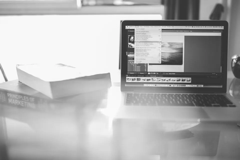 a laptop and a phone showing reports and charts on a desk