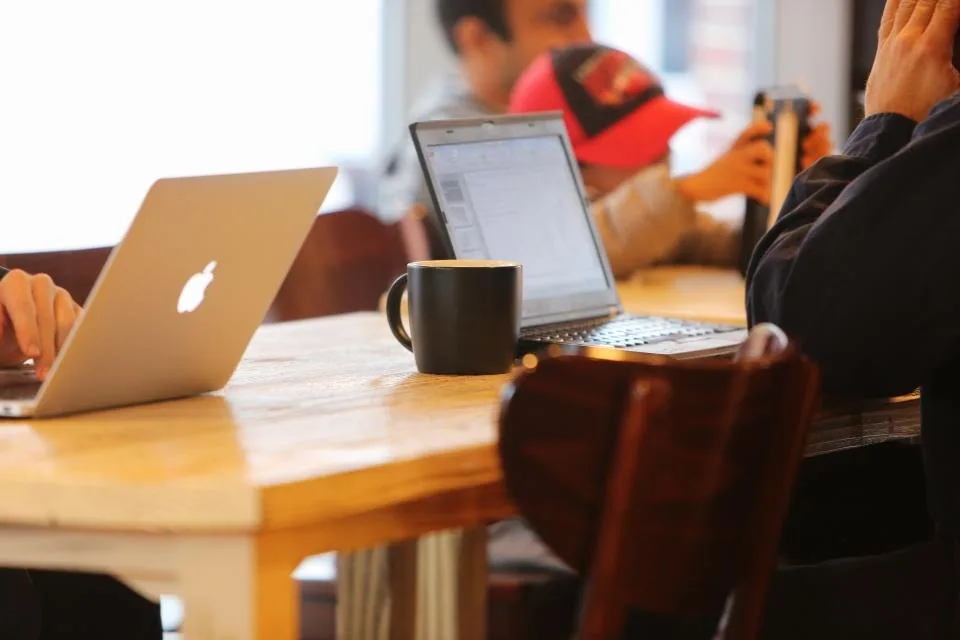 colleagues in discussion around a table with laptops open