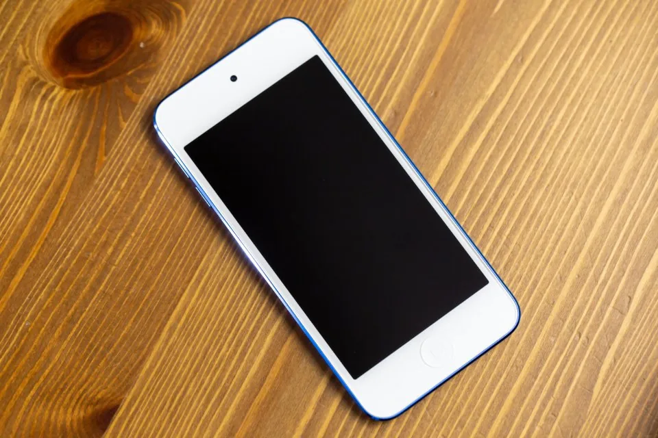 a smartphone and a laptop side by side on a desk with an app open