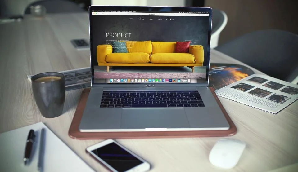 a smartphone and a laptop side by side on a desk with an app open