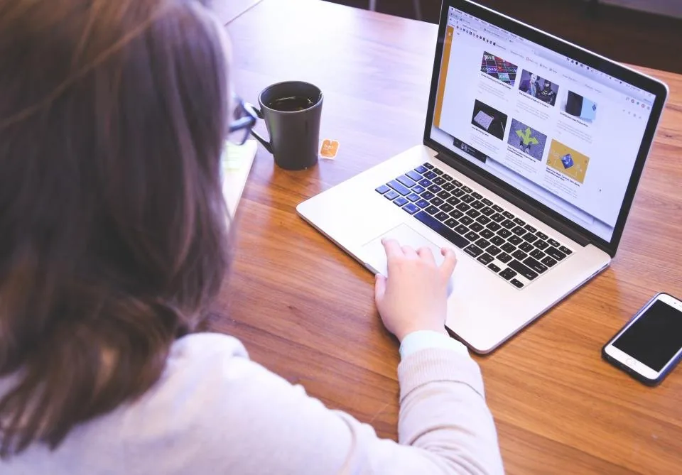 a team working at laptops around a table in a bright office