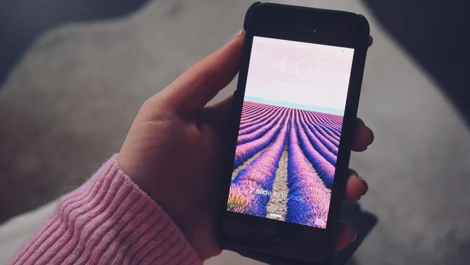 a hand holding a smartphone with the screen facing the camera