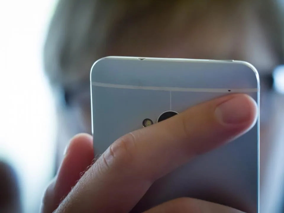 a hand holding a smartphone with the screen facing the camera