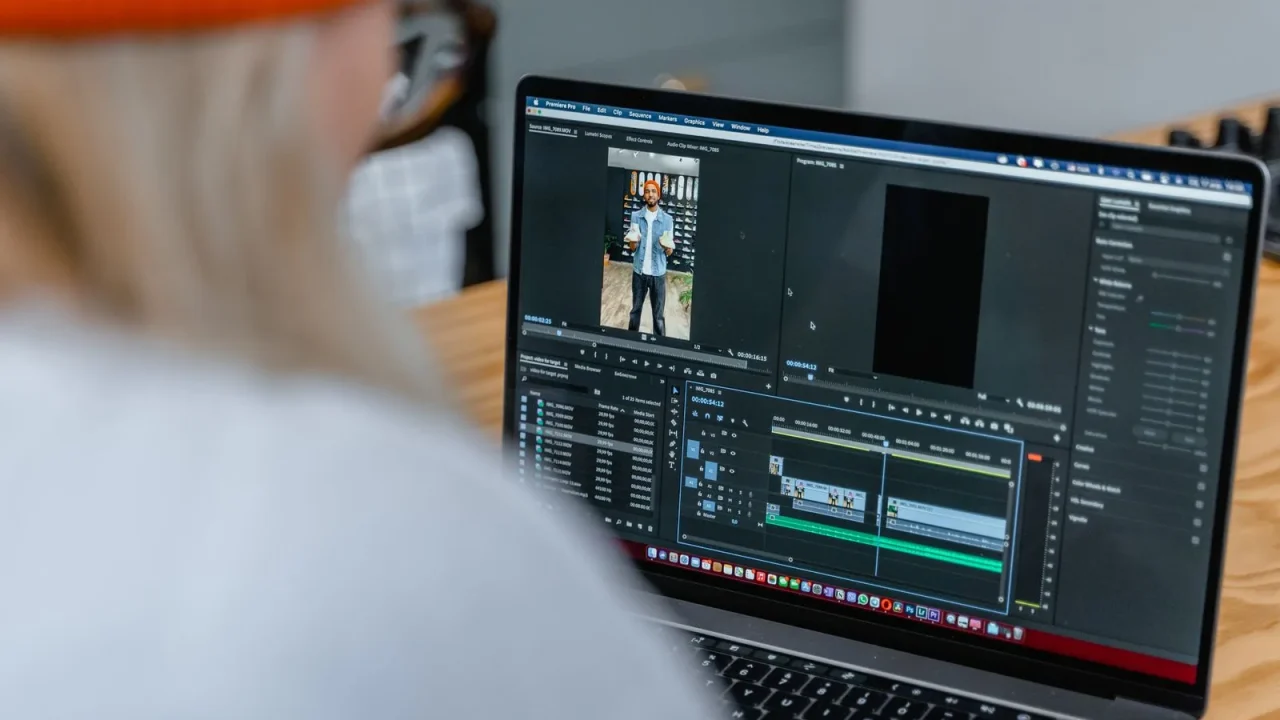 A person editing video on a laptop with a timeline open on screen.