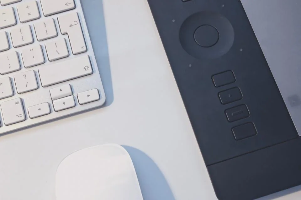 a tablet held and used at a desk beside a keyboard