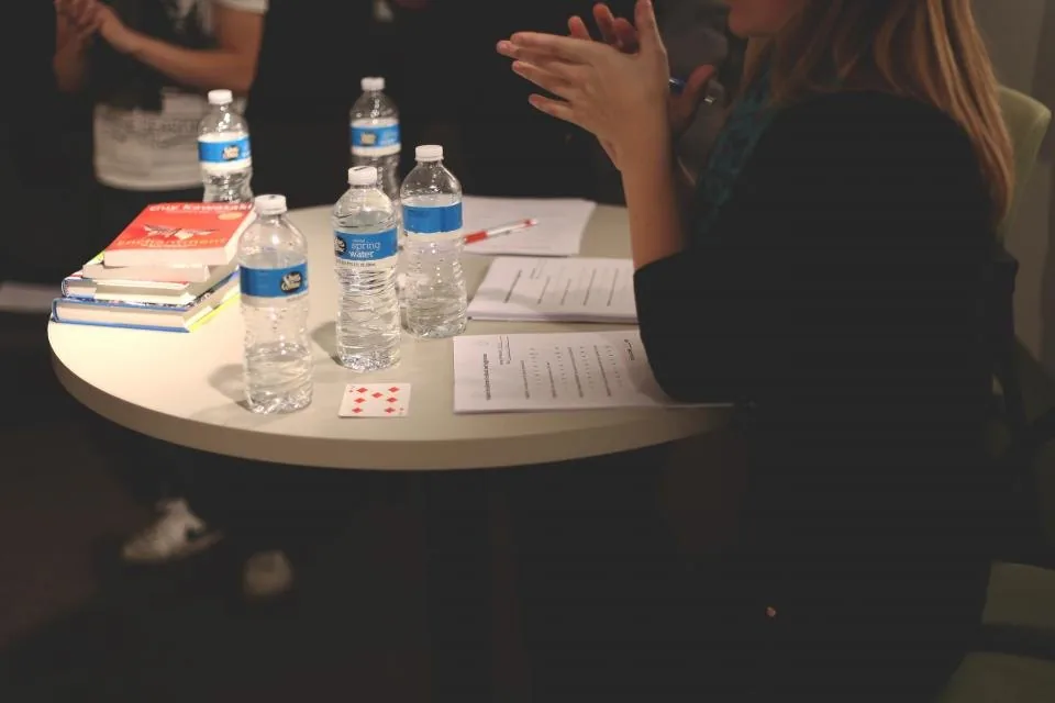 hands working together over a laptop and notes at a table