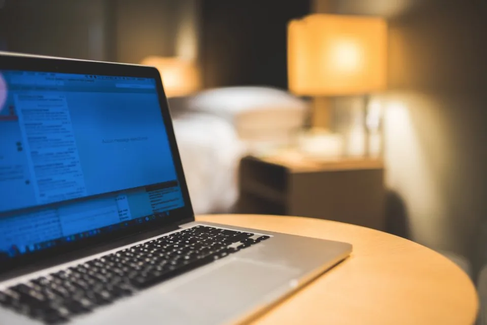 a desk by a window with a laptop open in daylight