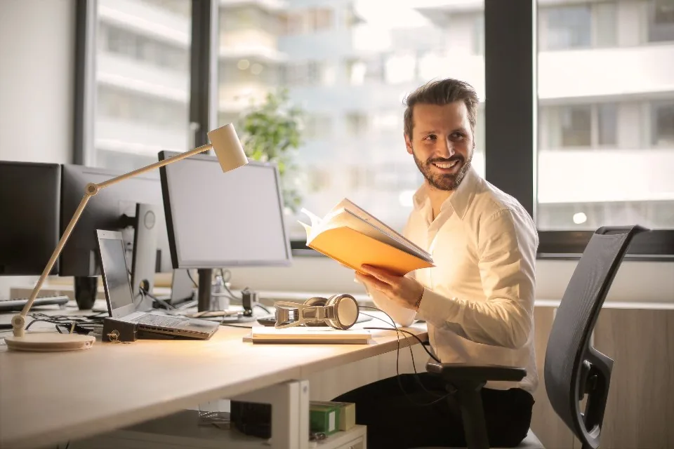 a desk by a window with a laptop open in daylight