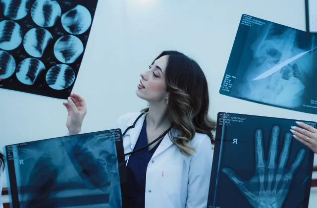 A medical professional reading diagnostic films on a light box.