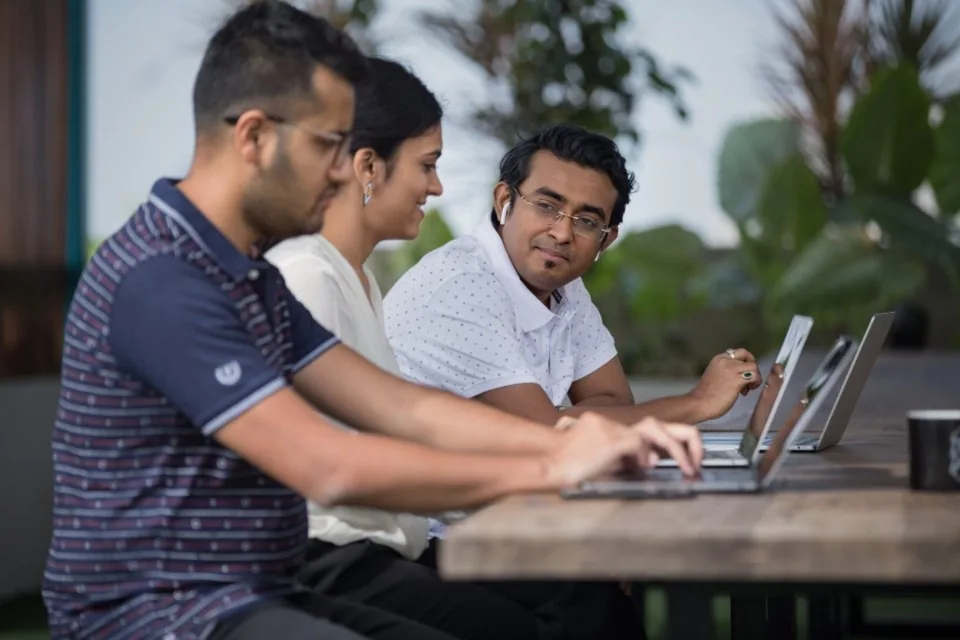 colleagues working together around laptops in a bright office